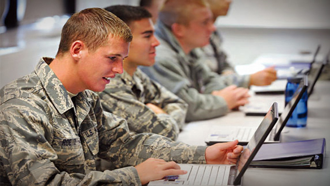 Service members working on laptops