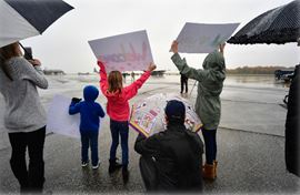families holding up signs and flags