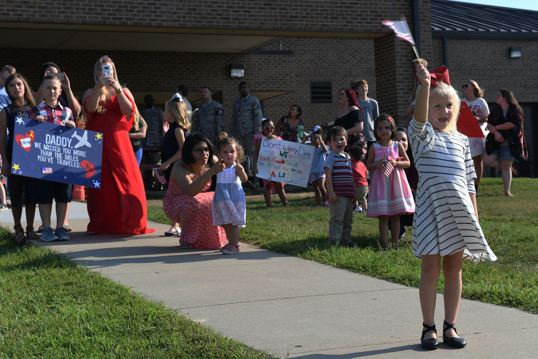 families holding up signs and flags