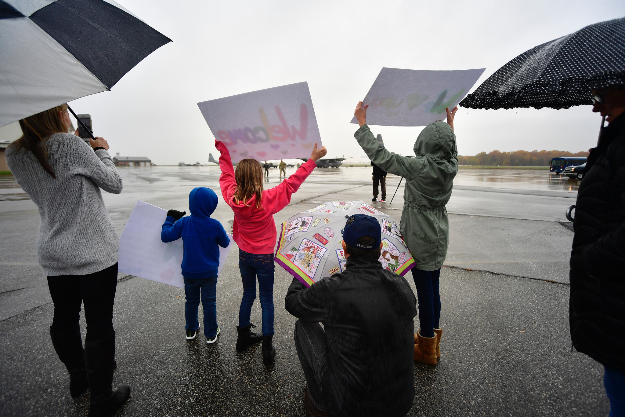 holding signs welcoming airmen home