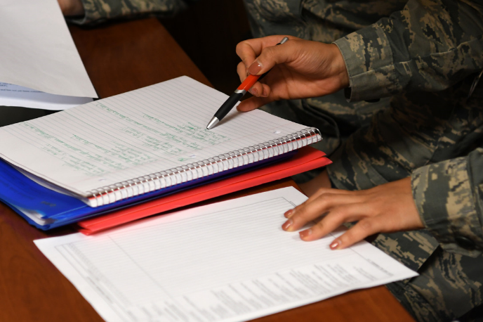 Service member writing on a notepad